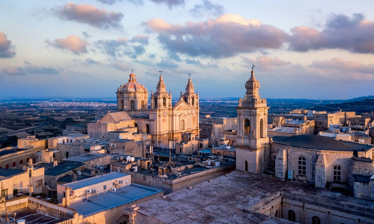 Sunset view of historic cathedral towers in a European city.