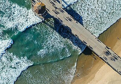 Aerial view of pier over ocean waves.