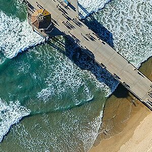 Aerial view of pier over ocean waves.
