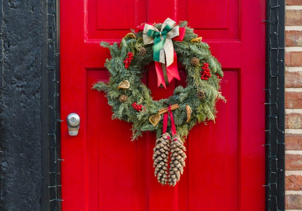 Red door with festive Christmas wreath decoration.