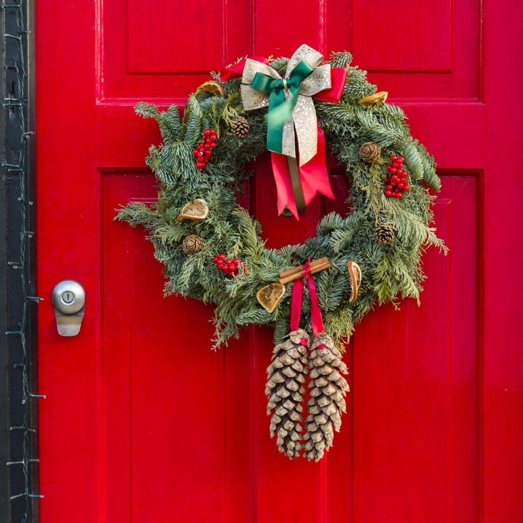Red door with festive Christmas wreath decoration.